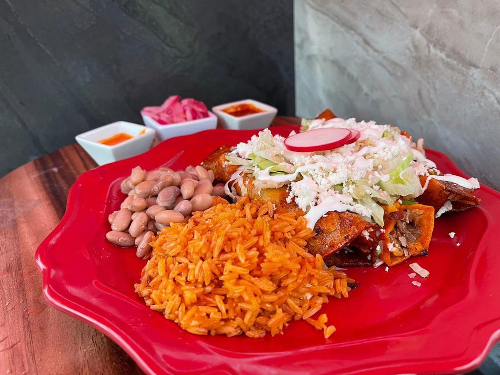 Enchilada Plate · 3 corn tortillas in deep homemade sauce with shredded chicken, rice, beans, lettuce, fresh cheese, onions and cilantro, sour cream.