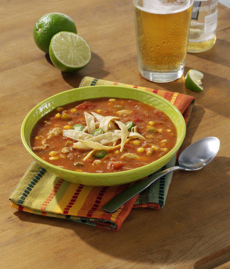 Chicken Tortilla Soup · Crumbled corn tortilla chips, tender chicken and vibrant tomatoes in a handcrafted chicken stock with sweet corn, green chilies, chopped cilantro and a touch of lime.