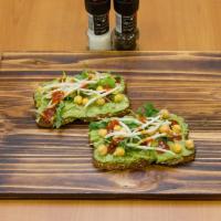 Garlic Chickpea Avocado Toast · Multigrain toast, avocado spread, garlic, chickpeas, arugula, and red chili paste.