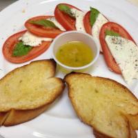 Caprese Salad · Fresh tomatoes, fresh mozzarella, fresh basil and garlic olive oil, served with bread and yo...