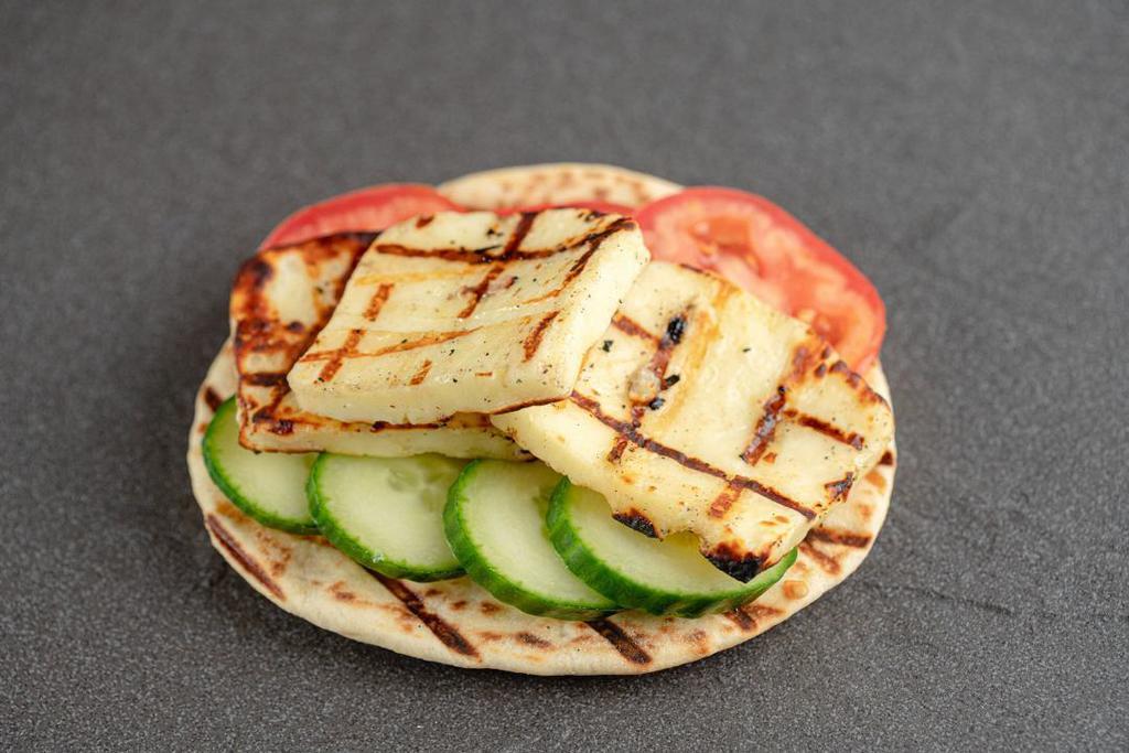 Grilled Halloumi · Halloumi is a Cypriot semi-hard cheese that is grilled and served with sliced cucumber, Tomato, and Pita bread garnished with fresh crushed oregano.