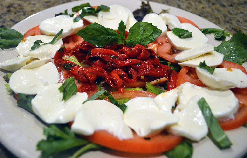 Caprese Salad · Fresh mozzarella and tomato topped with basil and extra virgin olive oil.

