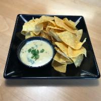 Queso Dip · Slightly spicy white cheese dip with chopped jalapenos and red peppers. With fresh made tort...