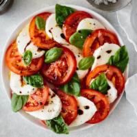 Caprese · Mozzarella, vine-ripened tomatoes, roasted peppers, basil pesto and extra virgin olive oil.