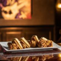 Chicken and Waffles · Crispy buttermilk-battered chicken wings, fresh-baked waffles, and a Bourbon Foster sauce.