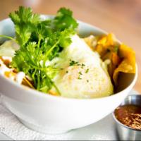 Migas · corn chips, roasted poblano, onion, tomato, cheddar sauce, cotija cheese, fried egg, cilantr...
