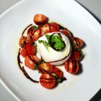 Burrata · Pulled cow milk cheese, grape tomatoes, basil, and balsamic reduction.