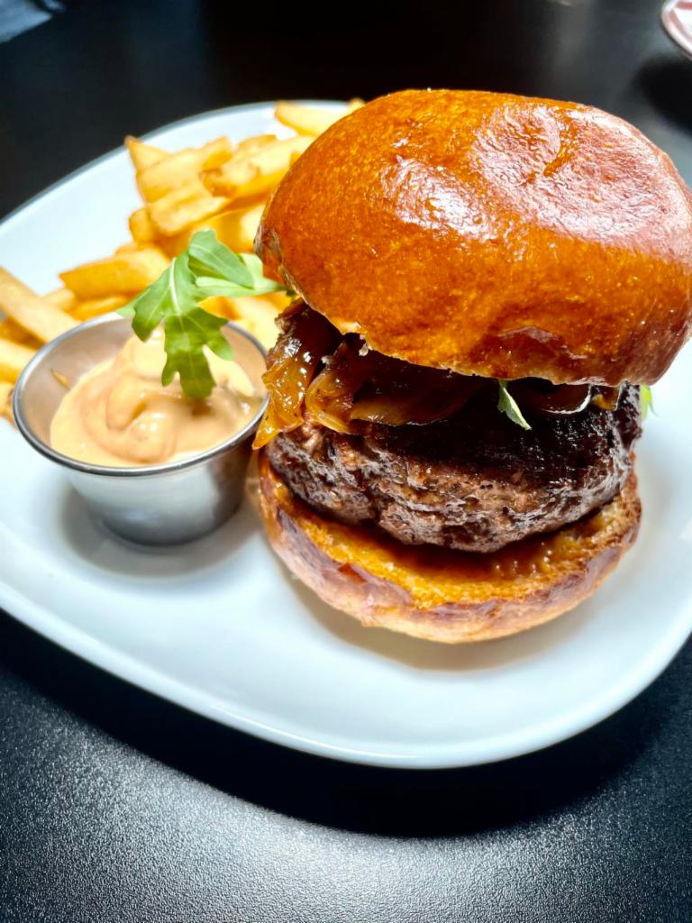 Industry Burger · 9 oz. grass fed, caramelized onions, smoked paprika aioli, arugula, and french fries.