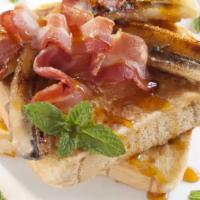 Bacon French Toast with Syrup · Fresh fluffy French toast topped with slices of bacon and syrup.