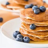 Blueberry Pancakes · 3 pieces of fluffy buttermilk pancakes with blueberries, and syrup.