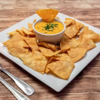 Queso Fundido con Chorizo · Served with chips.