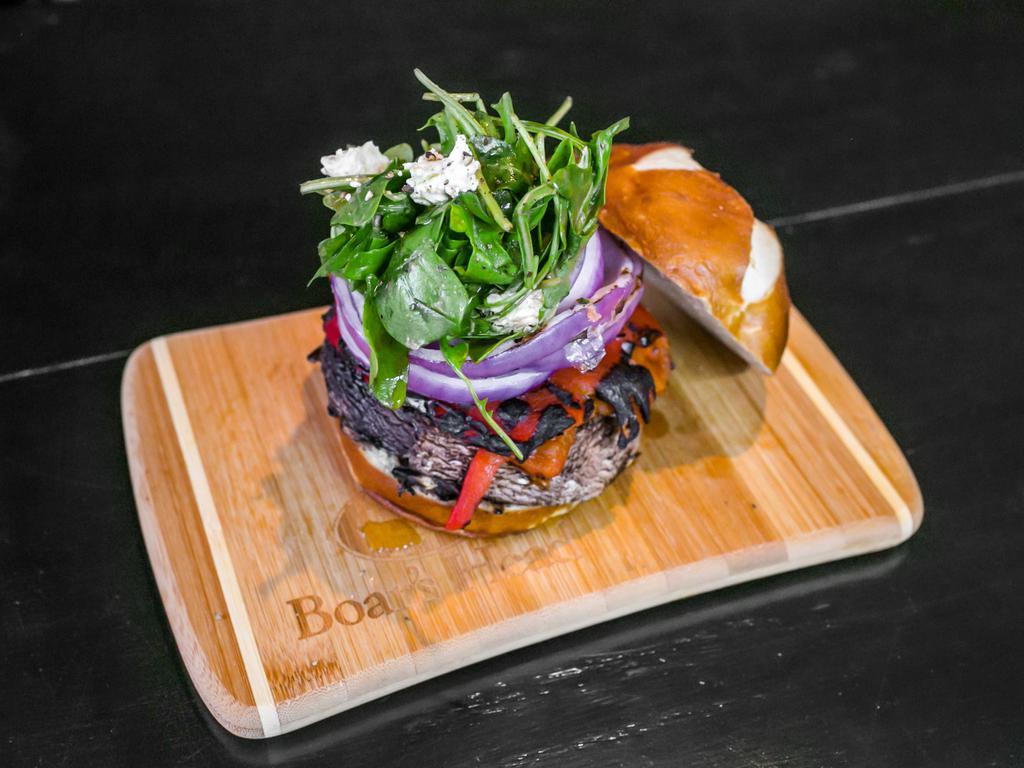 Portobello Burger · Portobello mushroom burger topped with goat cheese, grilled red onion, roasted peppers, arugula, and goat cheese with a side of sweet potatoes fries.