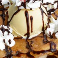 Sopapilla with Ice Cream · A sopapilla topped with ice cream, whipped cream, chocolate syrup, and a cherry.
