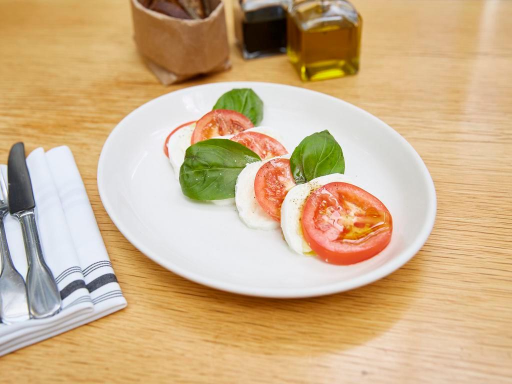 Caprese Salad · Served with Mozzarella di bufala, sliced tomatoes and fresh basil.