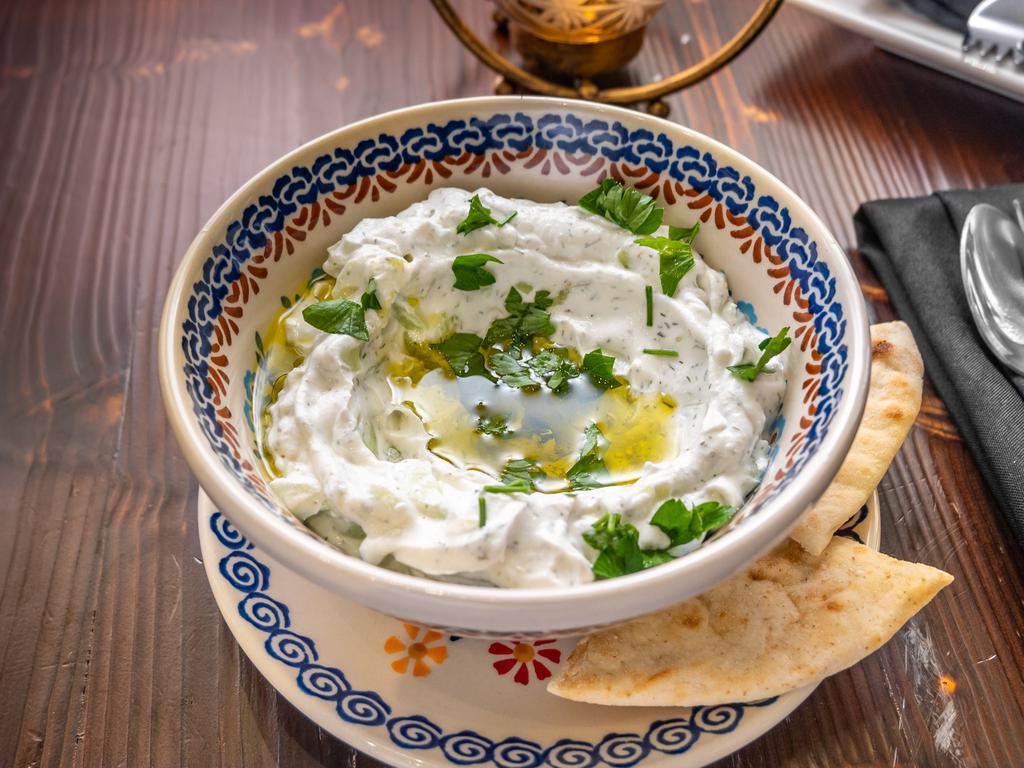 Yogurt Dip with Pita Bread · Fresh yogurt with mint and various varieties of spices topped with olive oil.