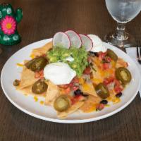 Nachos Regulares · Served with jack and cheddar cheese, black beans, sour cream, jalapeños, guacamole and pico ...