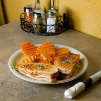 Toasted Monte Cristo Panini · Layers of ham and smoked turkey, Swiss, cheddar, lettuce, tomato and honey mustard.