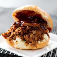 Root Beer Pulled Pork Sandwich · Tender pork shoulder slowly braised in root beer and herbs and spices. On a fresh bakery bun...