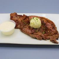 Rib-Eye Steak · Prime cut of extra tender 14 oz. rib-eye steak with light seasonings. Topped with garlic-her...