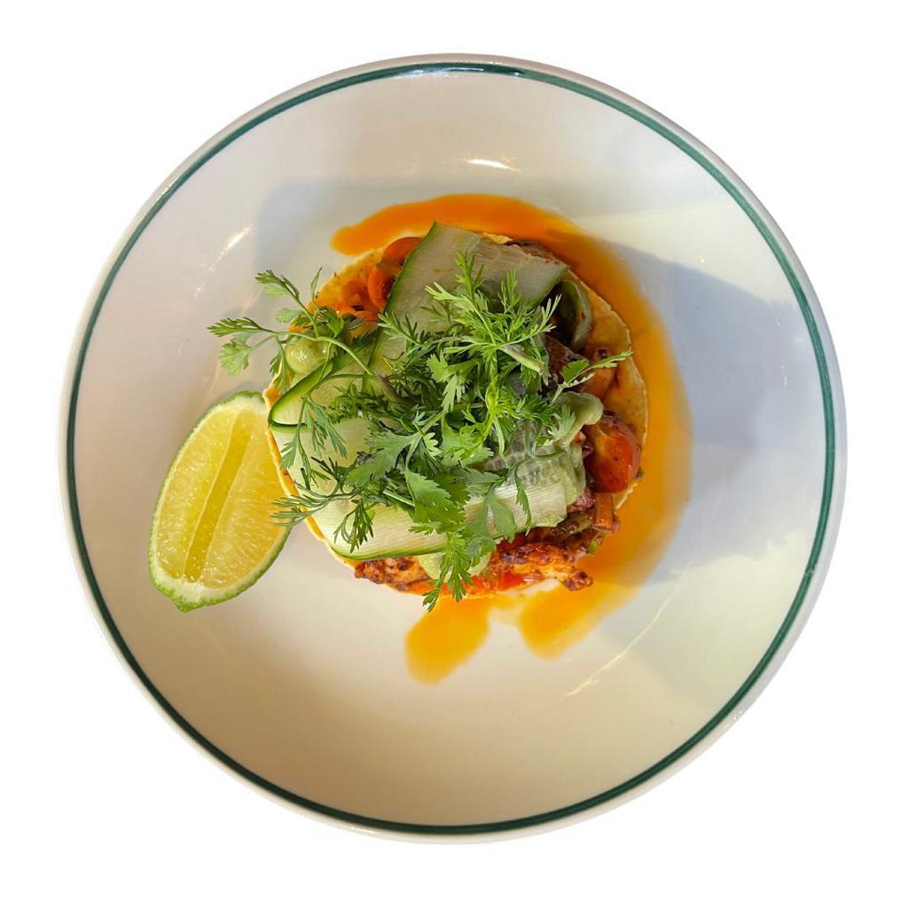 Tostada de Pulpo · Octopus escabeche, radish, carrot, avocado, onion, black cherry tomato and salsa macha this salsa is made with a variety of smoked chiles, peanuts and sesame seeds.