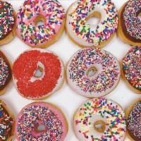 Dozen Sprinkle Donuts · Verities of sprinkled donuts (chocolate and pink).