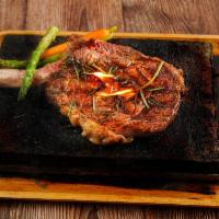 Ribeye Steak · Ribeye steak cooked at temperature of your preference topped with mushroom sauce served with...