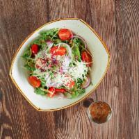 Arugula Salad · Fresh arugula topped with onions, parmesan cheese, tomatoes, olive oil and balsamic vinaigre...