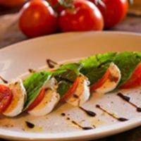 Insalata Caprese · Perfectly ripened Roma tomatoes, fresh mozzarella, and garden-fresh basil, drizzled with bal...