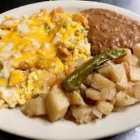 Chilaquiles con Huevo · Two scrambled eggs with spicy hot tortilla bits, topped with cheese and served with fried po...