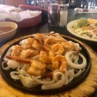 Cameron a la Plancha · Jumbo Gulf shrimp sauteed in garlic butter served on a sizzling platter. It is served with g...