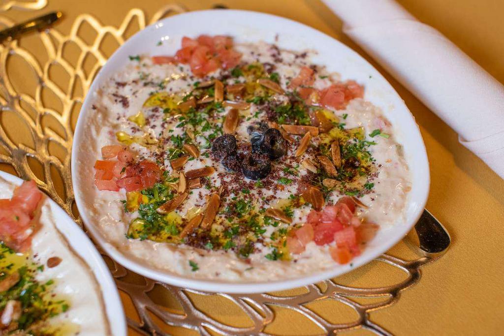 Hummus · Pureed chickpeas, tahini, lemon, nuts, and garlic drizzled with extra virgin olive oil, served with pita bread.