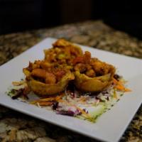 Tostones Rellenos · Mini plantain cups filled with shrimp in Criollo sauce.