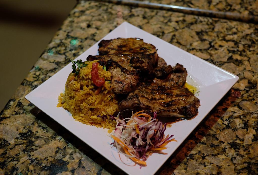 Chuletas a la Parrilla · Two juicy pork chops perfectly grilled. Served with your choice of side.