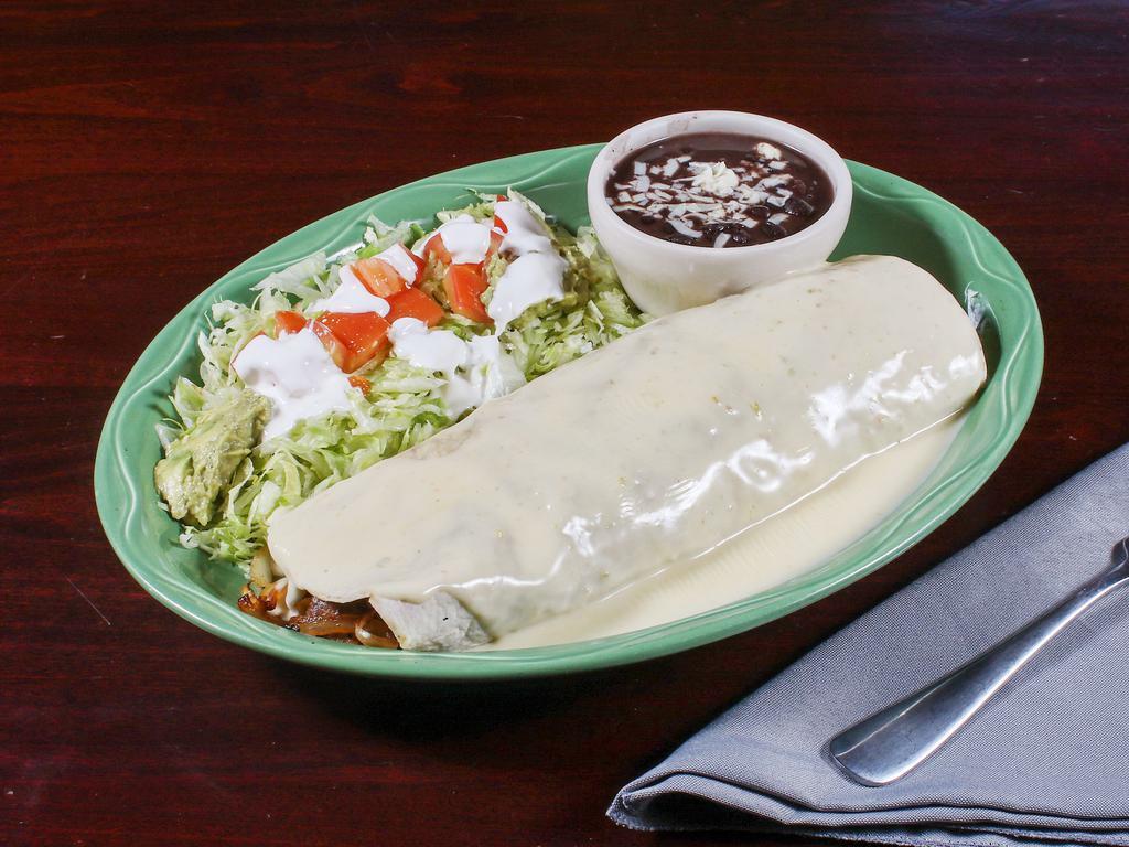 Steak Burrito · Steak grilled with bell peppers, onions and tomatoes. Topped with cheese sauce, lettuce, sour cream and guacamole. Served with black beans.