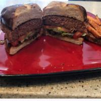 Urban Burger · Plant based burger severed on pretzel bun topped with lettuces, tomatoes, onions, & dill pic...