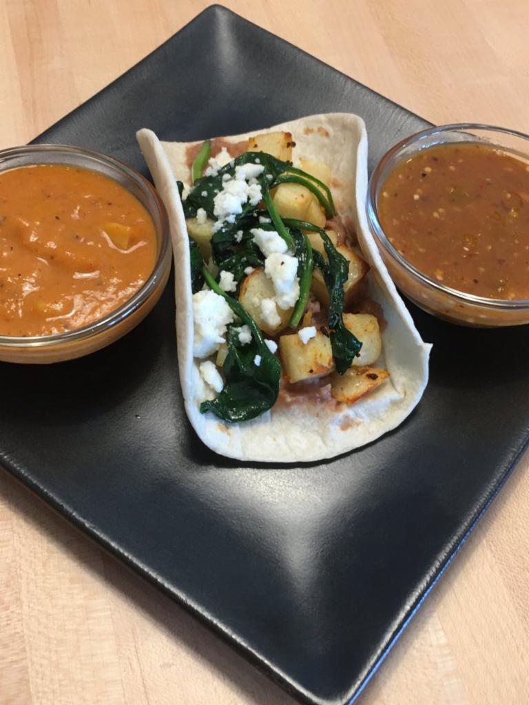 Bean, Potato, Spinach and Cheese Tacos · Creamy black beans, seasoned cubed potato, sautéed spinach, topped with queso fresco in a warm and handmade flour tortilla. Vegetarian.
