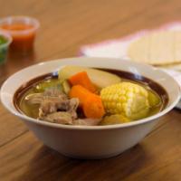 Caldo de res · Beef soup with vegetables and a side of corn tortillas.