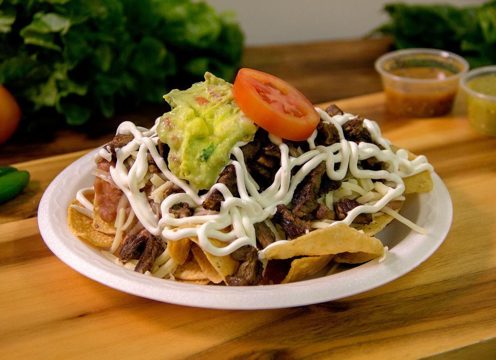 Nachos · They prepared with your choice of protein, beans, guacamole, sour cream, and Cotija cheese.