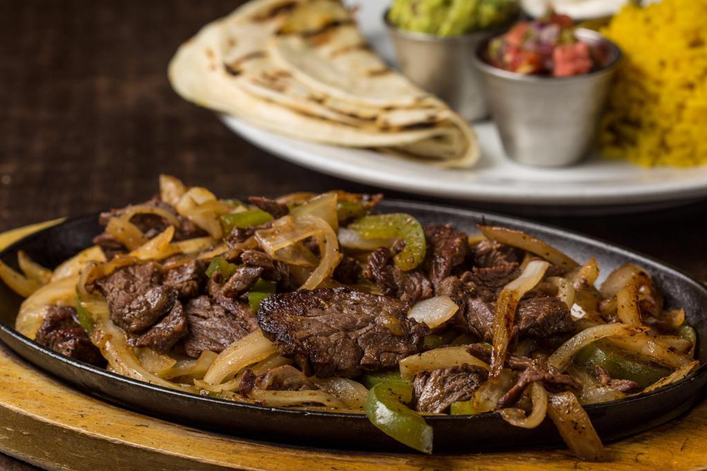Fajitas · Choice of chicken, steak or shrimp, sizzling with peppers and onions with rice, sour cream, pico de gallo, guacamole, and warm flour tortillas