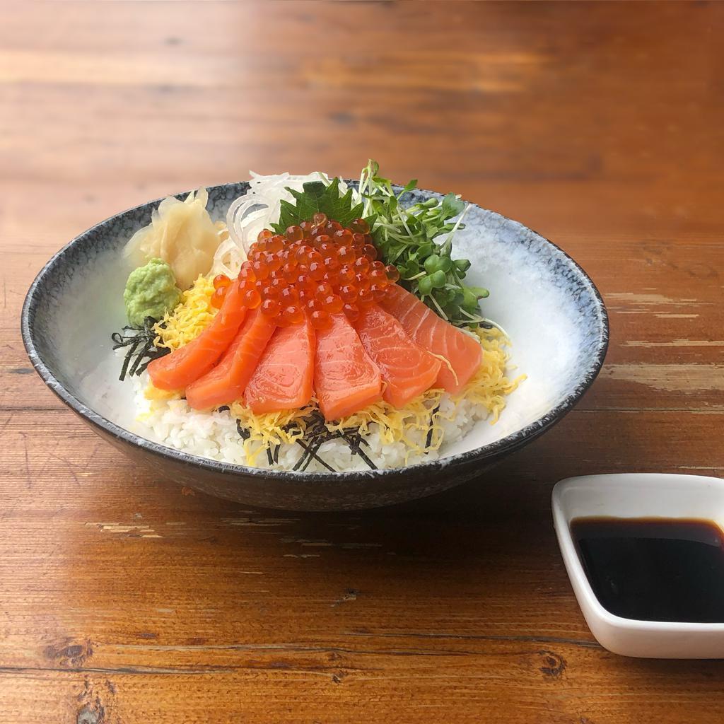 Sake Ikura Don · Salmon sashimi and marinated ikura garnished with daikon, kaiware, shredded egg, and shiso leaf over Japanese short-grain white rice. Served with zuke sauce. Raw.