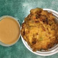 53. Pork Egg Foo Young · With steamed rice and gravy sauce on side.