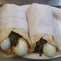 Taco de Huevo Hervido con Arroz · Two hard boiled eggs over Mexican rice in hand made corn tortilla.