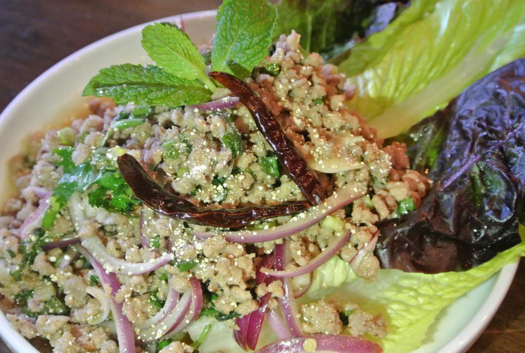 Laab E-sarn  · Lettuce wrapped salad. Choice of ground pork or chicken tossed with chili powder, red onion, mint, cilantro, scallion, roasted rice powder in spicy lime dressing wrapped in lettuce. Gluten free.