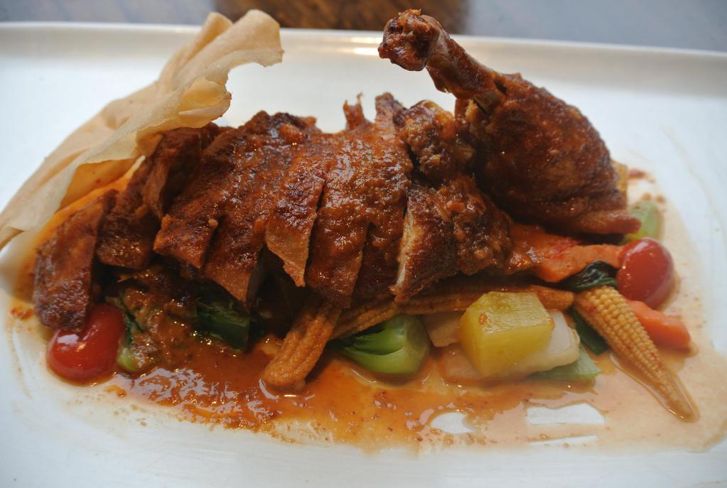 Thailand Duck · Crispy Long Island duck with basil, carrot, snow pea, bell pepper, tomato, and pineapple served with chef's special red curry sauce. Spicy.