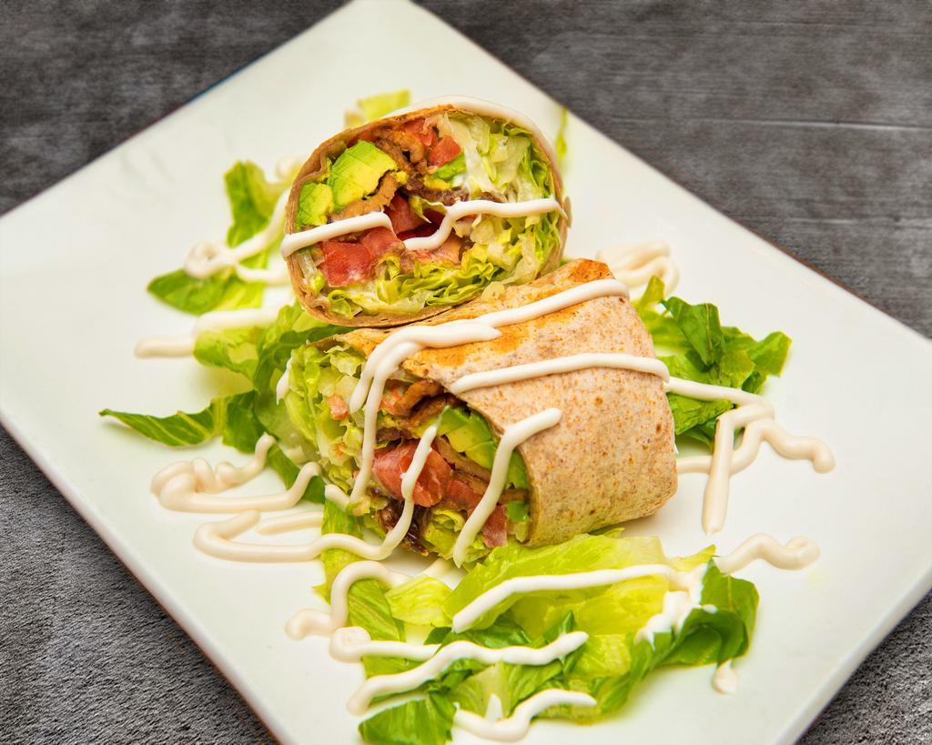 Notorious BLT · Organic smoked tempeh bacon, sauteed onions, avocado, lettuce, tomato, and vegan mayo in a whole wheat wrap