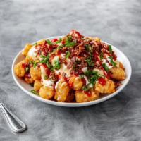 Gavacho's Totchos · Tots topped with cheesy sauce, crumbled bacon, green onions, sour cream, and satan's tears k...