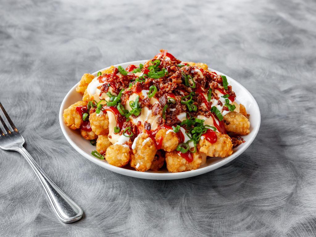 Gavacho's Totchos · Tots topped with cheesy sauce, crumbled bacon, green onions, sour cream, and satan's tears ketchup.
