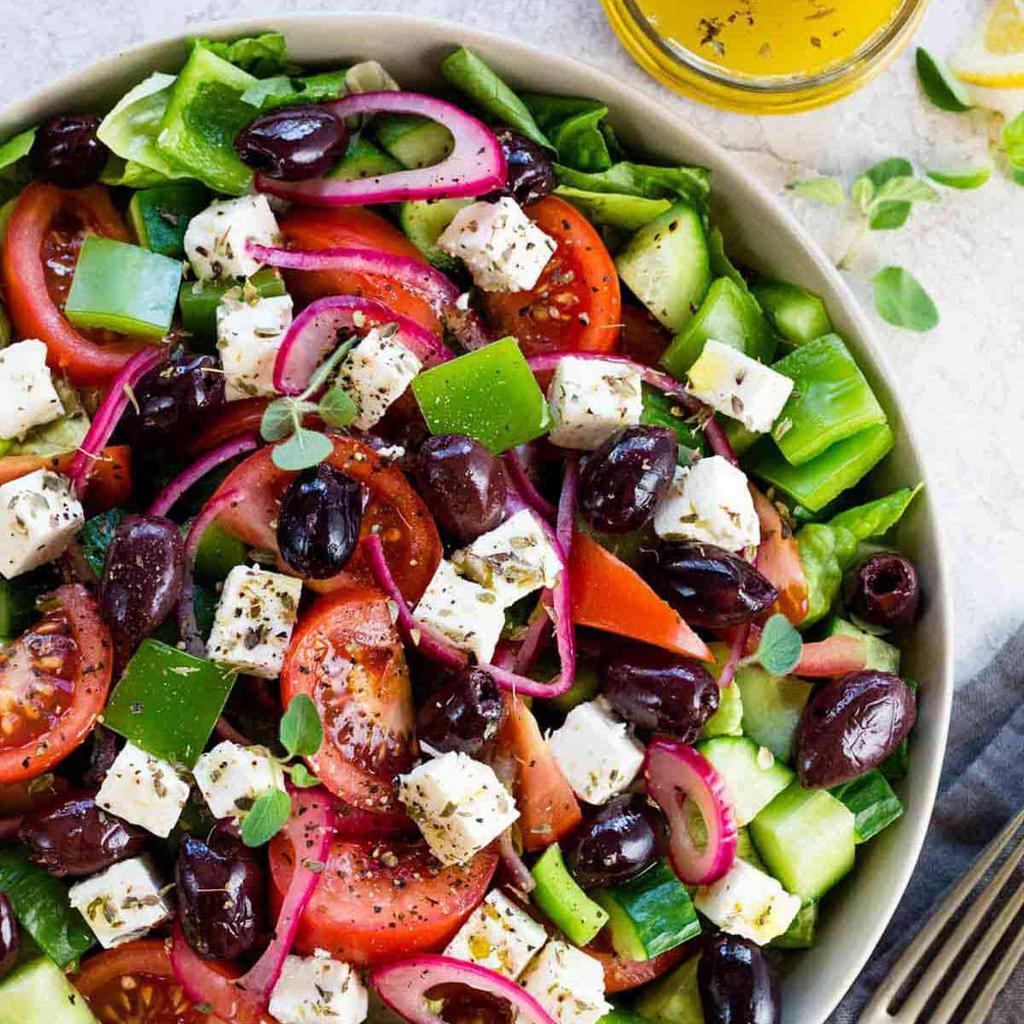 Fresh Chopped Greek Salad · It’s a combination of crisp vegetables and pickled onions tossed in a light and tangy homemade olive oil and vinegar dressing. Made with the perfect ratio of Romaine lettuce, feta cheese, red onions, pitted black olives, cucumbers and grape tomatoes