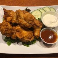 Chicken Wings · crispy fried chicken wings tossed in a tabasco sriracha sauce.  Served with a side of tzatzi...