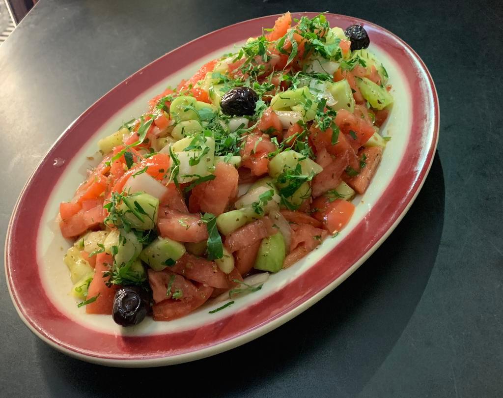 Shepherd Salad · Chunks of tomatoes, cucumbers, onions and green peppers dressed with olive oil and vinegar topped with parsley and black olives.